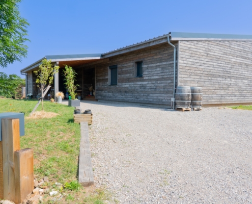 Maison à ossature bois de plain-pied avec une terrasse à l’arrière.