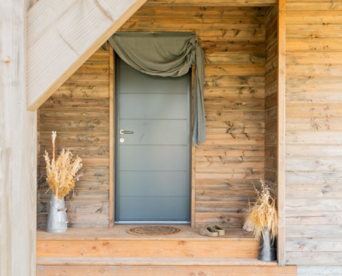 Maison à ossature bois de plain-pied avec une terrasse à l’arrière.