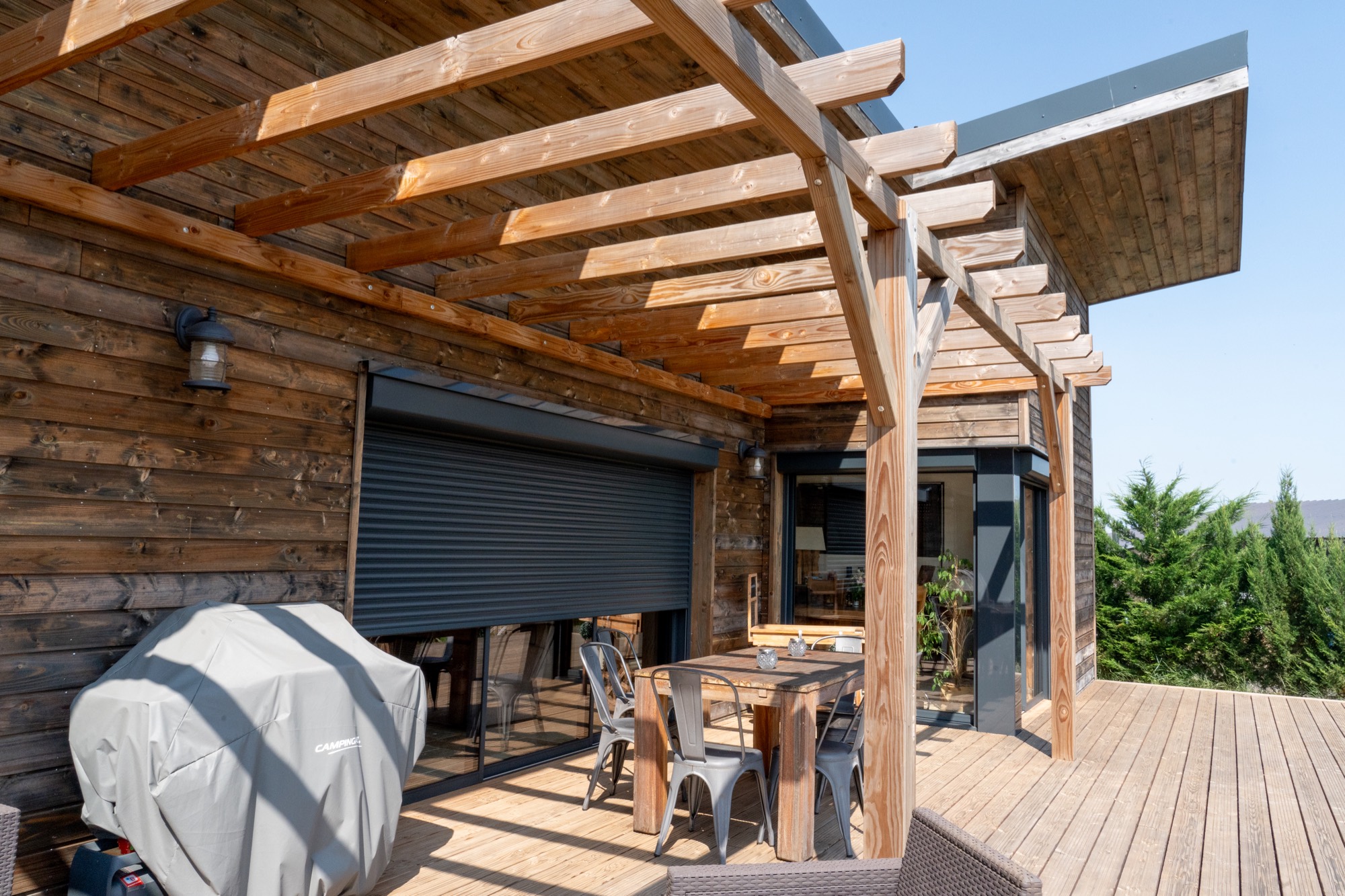 Maison à ossature bois de plain-pied avec une terrasse à l’arrière.