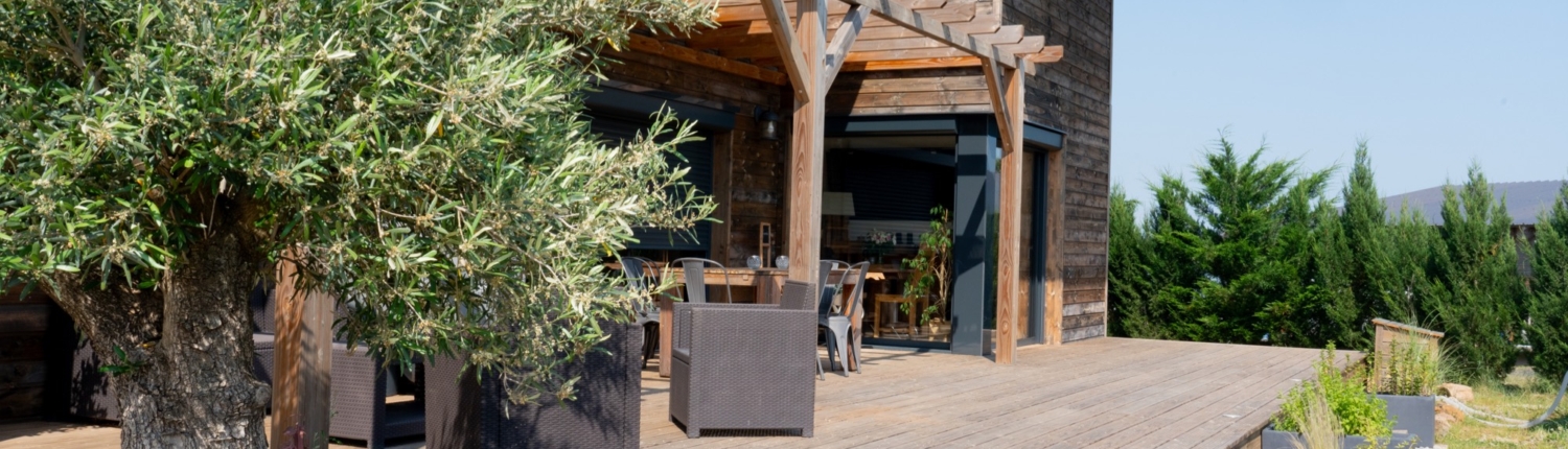 Maison à ossature bois de plain-pied avec une terrasse à l’arrière.