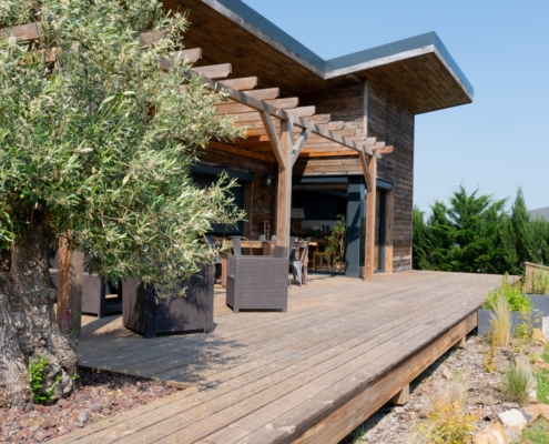 Maison à ossature bois de plain-pied avec une terrasse à l’arrière.