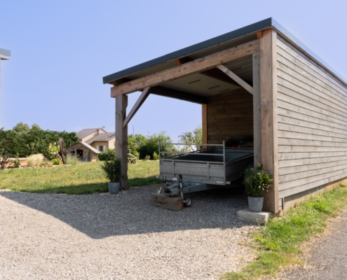 Maison à ossature bois de plain-pied avec une terrasse à l’arrière.