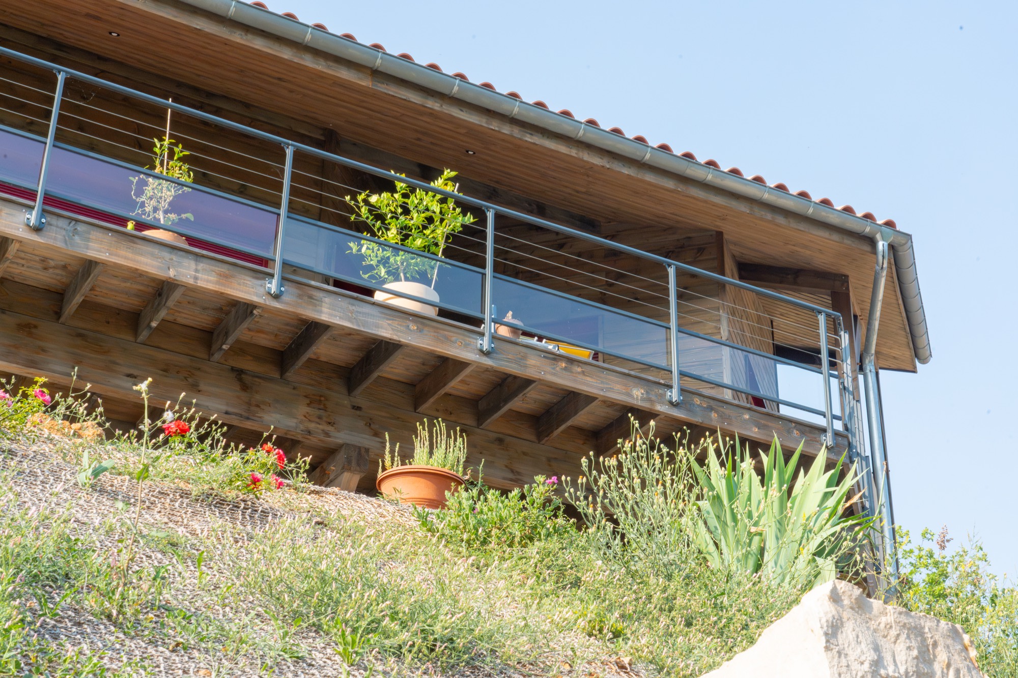 Maison à ossature bois avec une grande terrasse offrant une vue sur les montagnes
