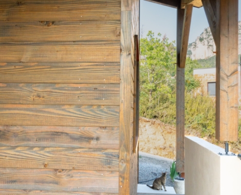 Maison à ossature bois avec une grande terrasse offrant une vue sur les montagnes