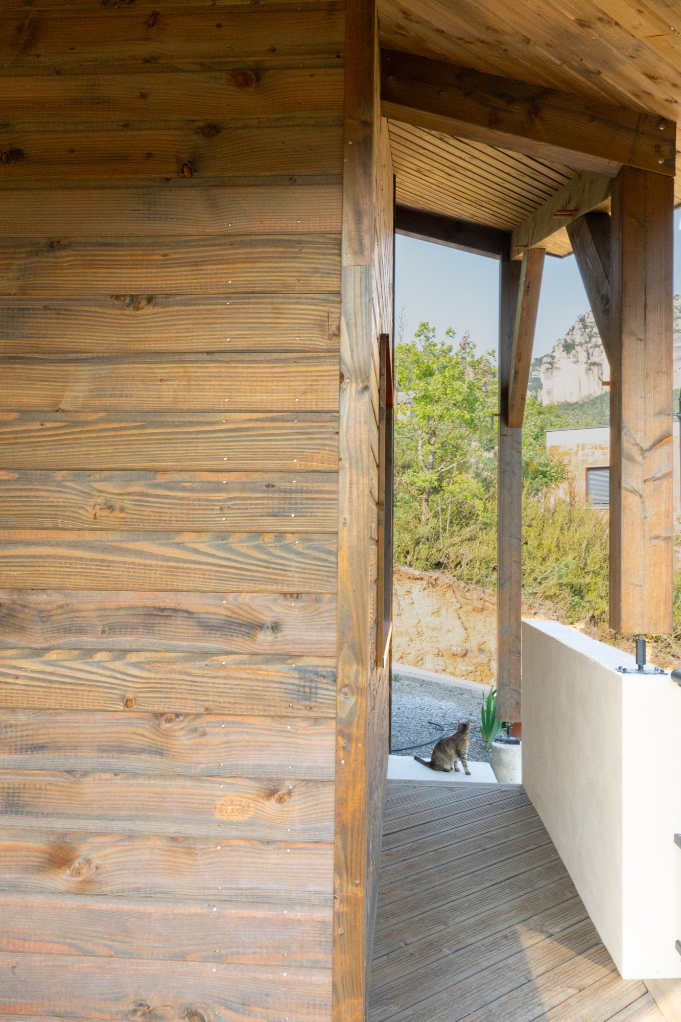 Maison à ossature bois avec une grande terrasse offrant une vue sur les montagnes